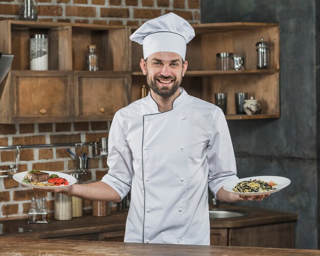 Chef masculino que presenta deliciosos platos en la cocina