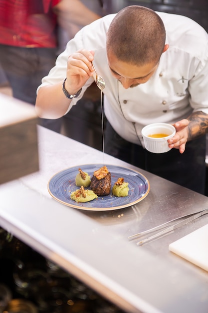 Chef mostrando su buena cocina. Decoración profesional de alimentos