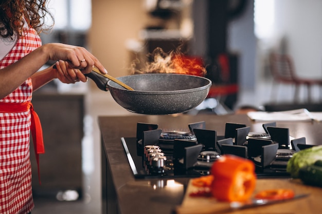 Chef mujer cocinar verduras en sartén