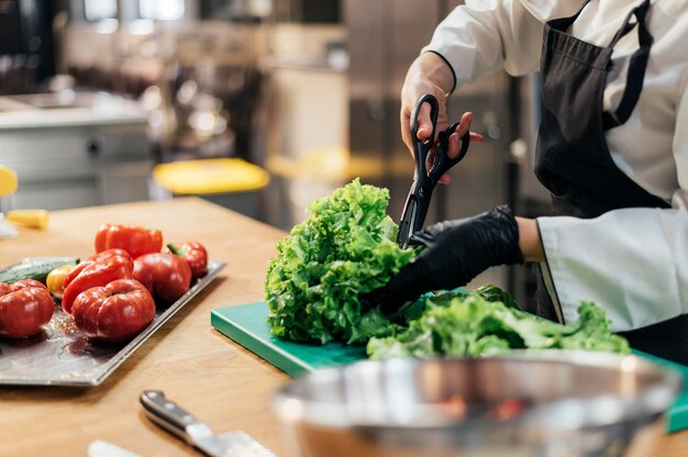 Chef mujer con ensalada de picar guante