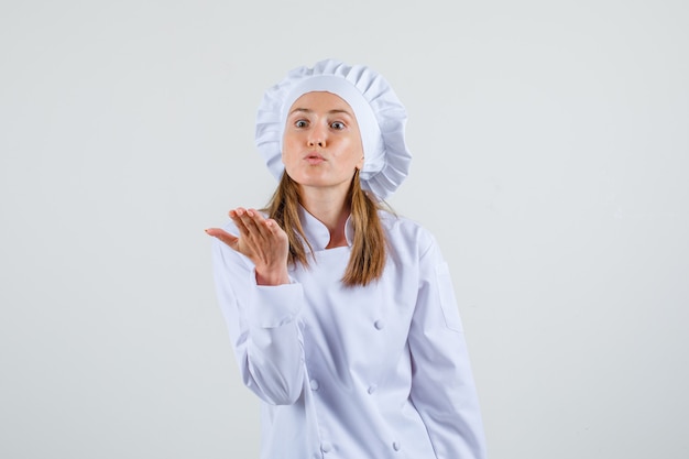 Chef mujer gritando a alguien en uniforme blanco y con enojo. vista frontal.