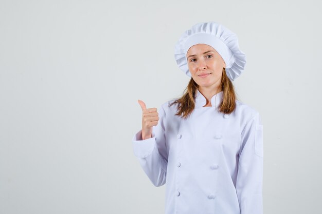 Chef mujer mostrando el pulgar hacia arriba y sonriendo en uniforme blanco