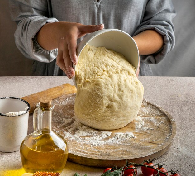 Chef mujer poniendo masa para pizza sobre tabla de madera