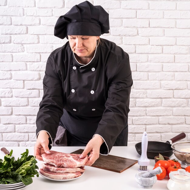 Chef mujer preparando carne