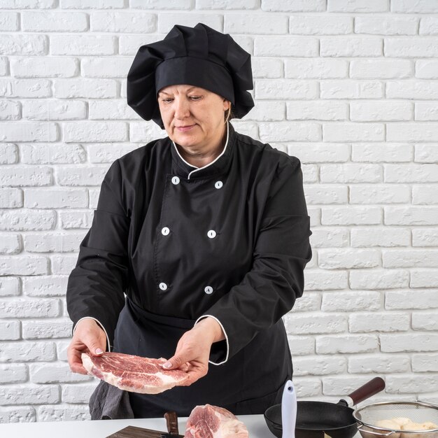 Chef mujer preparando carne