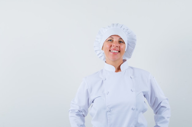 Chef mujer en uniforme blanco mirando al frente y mirando confiado