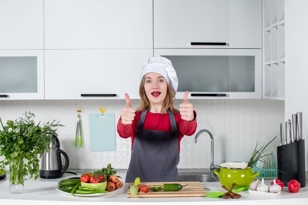 Chef mujer vista frontal en sombrero de cocinero dando pulgar hacia arriba