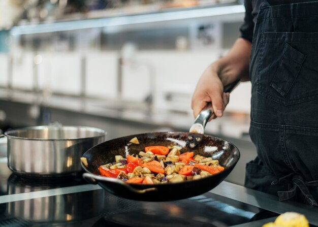 Chef con plato de cocina delantal en la cocina