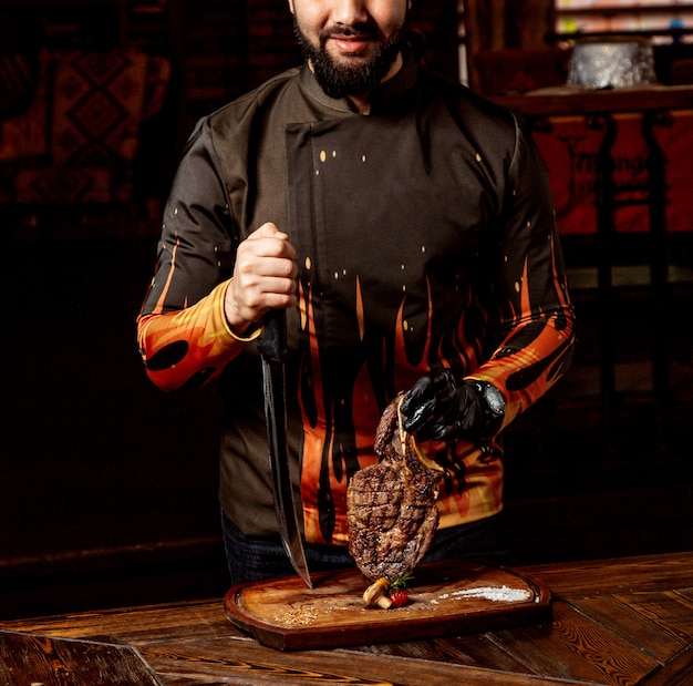 Chef pone carne frita en la tabla de cortar