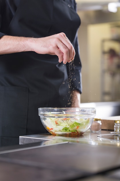 Foto gratuita chef preparando una ensalada