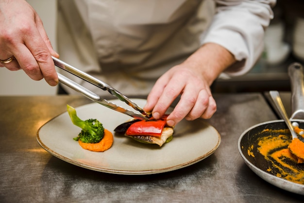 Chef preparando plato gourmet vista frontal