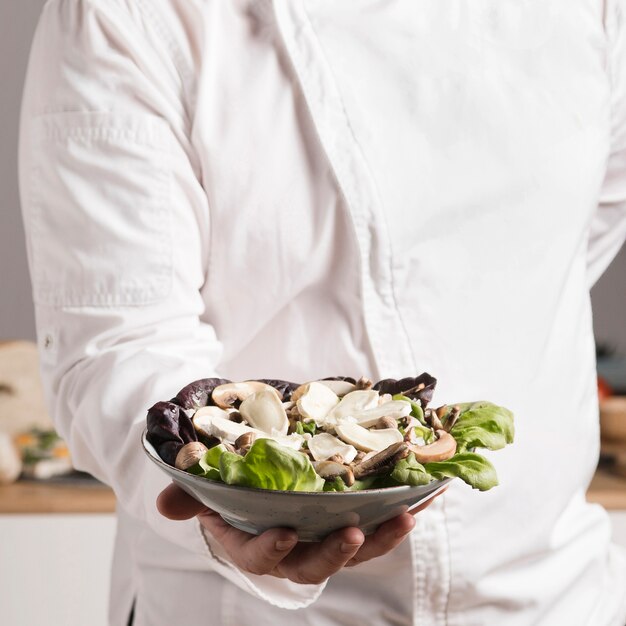 Chef de primer plano con plato de comida