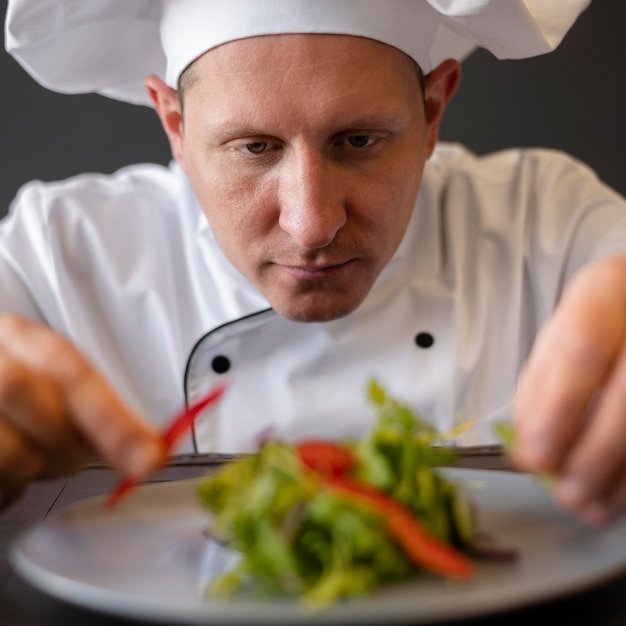 Chef de primer plano preparando plato