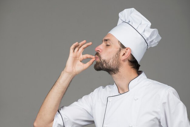 Chef profesional hombre mostrando signo de delicioso