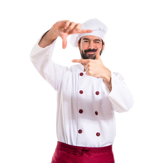 Foto gratuita chef que se centra con sus dedos en un fondo blanco