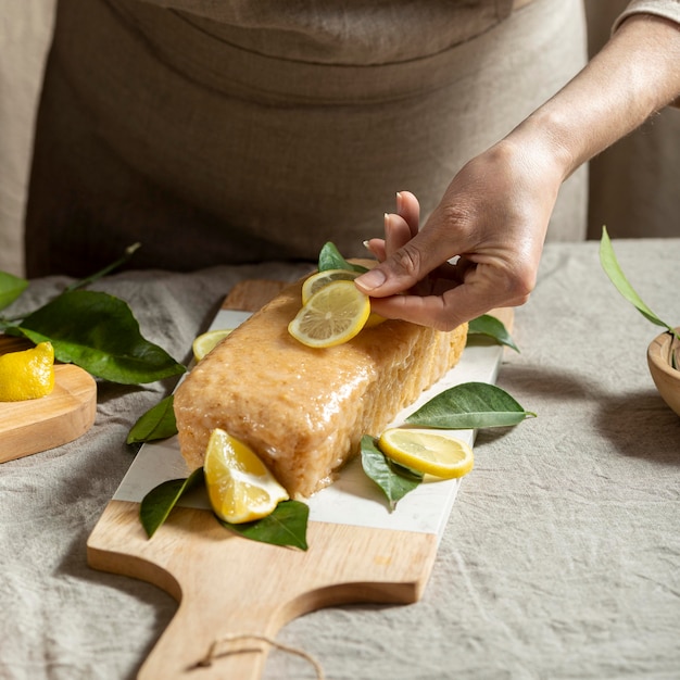 Foto gratuita chef de repostería añadiendo rodajas de limón a la cobertura de la torta