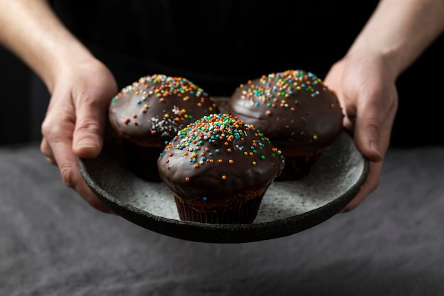 Chef de repostería con plato con muffins de chocolate