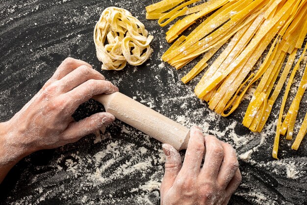 Chef con rodillo cerca de pasta