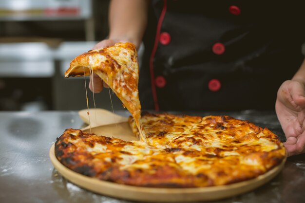 chef tomando pizza en la cocina