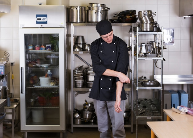 Chef con uniforme y menaje de cocina