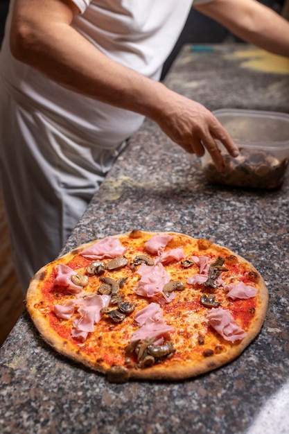 Chef de vista lateral preparando pizza