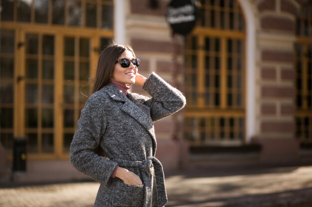 Chica en abrigo de pie en la calle