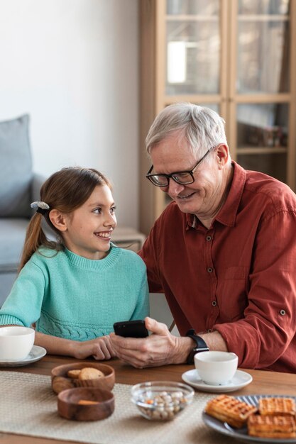 Chica y abuelo sonriente de tiro medio