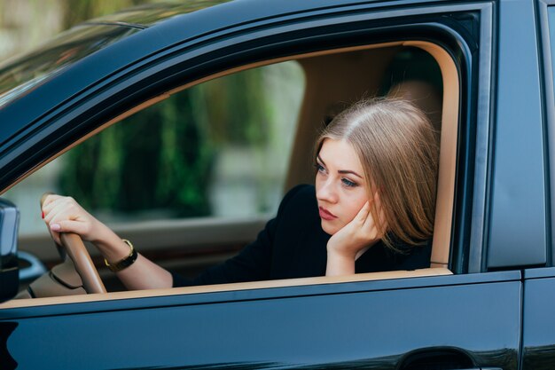 Chica aburrida en su coche en el atasco de tráfico