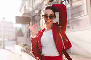 Foto gratuita chica activa en grandes gafas de sol divirtiéndose en la calle