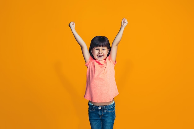 Foto gratuita chica adolescente de éxito feliz celebrando ser un ganador. imagen dinámica enérgica del modelo femenino