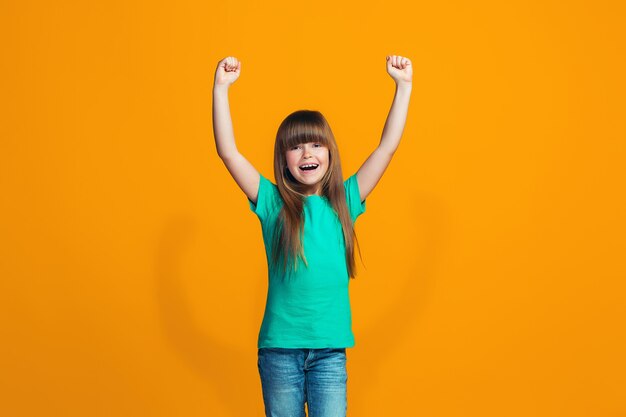 Chica adolescente de éxito feliz celebrando ser un ganador. Imagen dinámica enérgica del modelo femenino