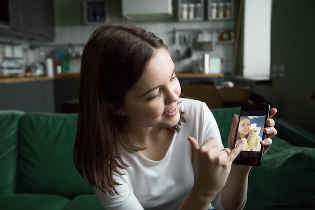 Chica adolescente haciendo videollamada o videoblog hablando sobre la imagen del teléfono inteligente