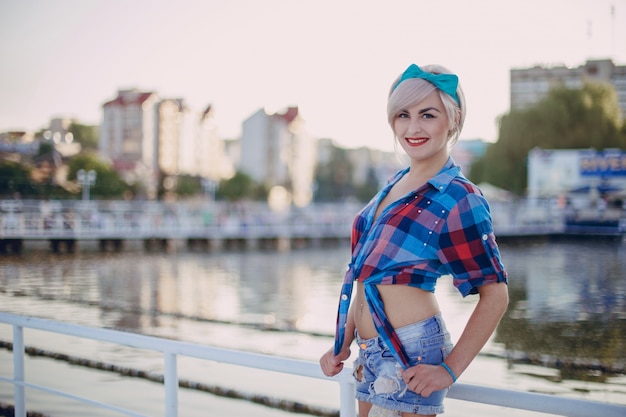 Chica adolescente posando con una camiseta corta a cuadros