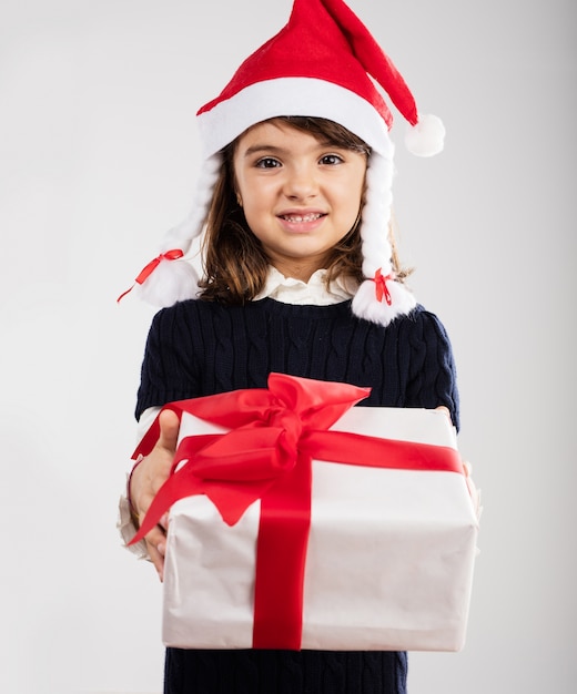 Chica adorable sujetando un regalo rojo