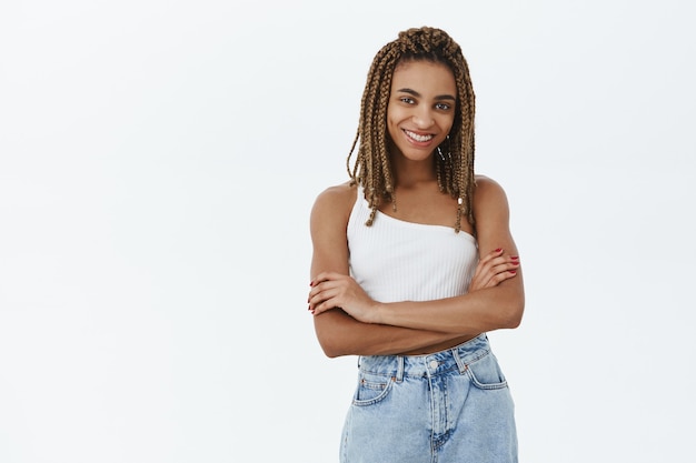 Foto gratuita chica afroamericana con estilo confidente cruza los brazos y parece complacido, sonriendo