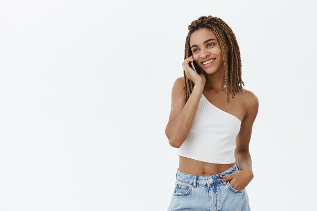 Chica afroamericana moderna con estilo con smartphone