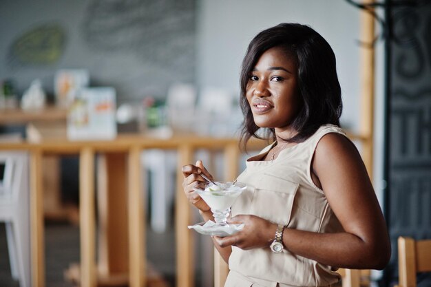 Chica afroamericana posó en el café y comiendo helado