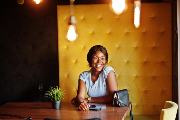 Chica afroamericana sentada en el café Mujer negra descansando