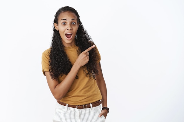 Chica afroamericana sorprendida y asombrada en camiseta marrón