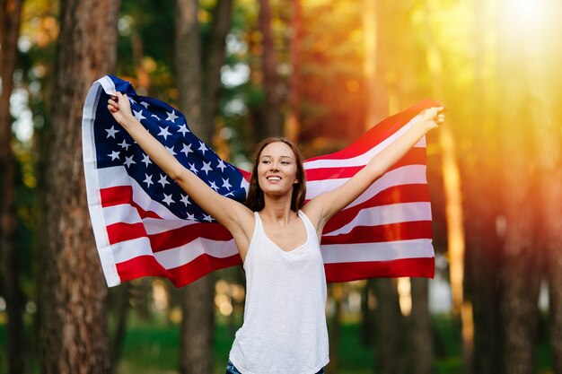 Chica agitando la bandera estadounidense.