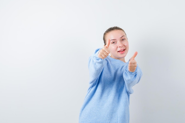 La chica agradable muestra que todo está bien en el fondo blanco