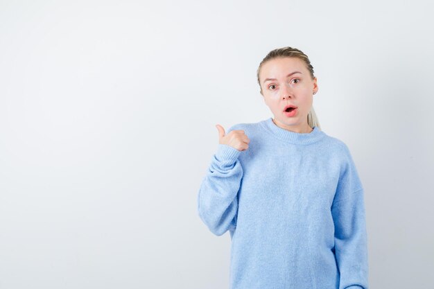 Chica agradable sorprendida por el sonido que viene de la derecha sobre fondo blanco.