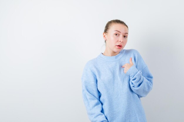 La chica agradable se ve tan sorprendida en el fondo blanco