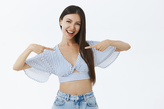 Chica alardeando sobre su propio logro ganando el concurso de belleza apuntando a sí misma produly y felizmente sonriendo alegre