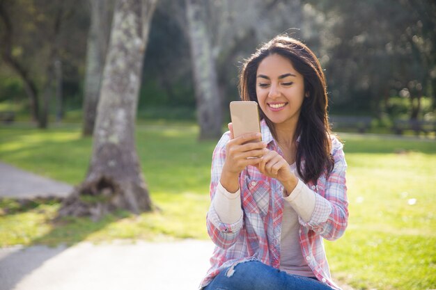 Chica alegre alegre feliz de usar conexión inalámbrica en parte