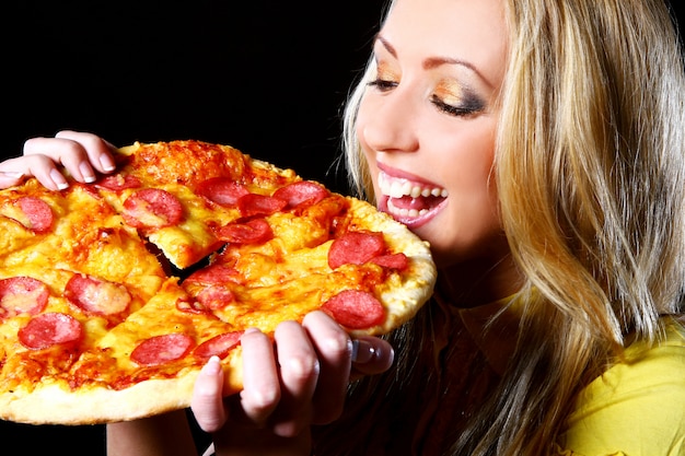 Chica alegre comiendo pizza