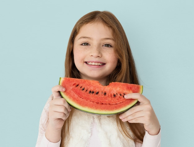 Chica alegre joven sosteniendo una rebanada de sandía