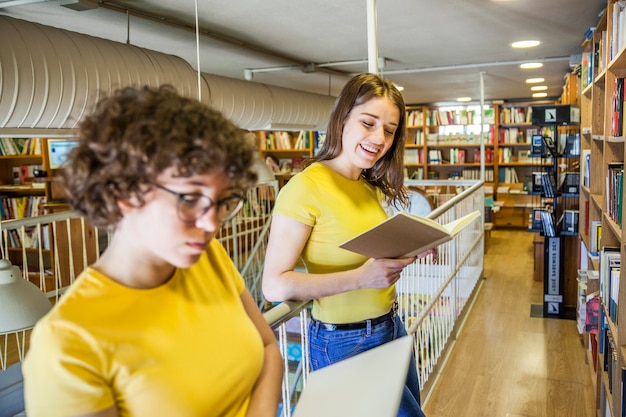 Foto gratuita chica alegre leyendo cerca de amigo inteligente