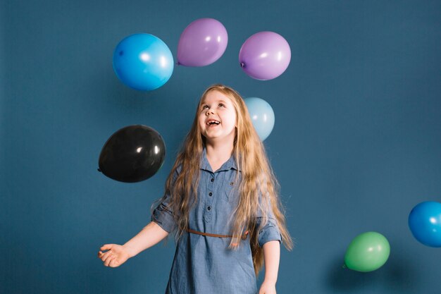 Chica alegre mirando globos