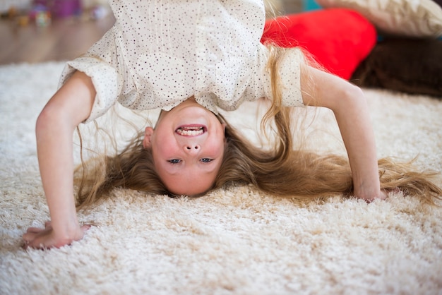 Foto gratuita chica alegre mostrando una pose de headstand